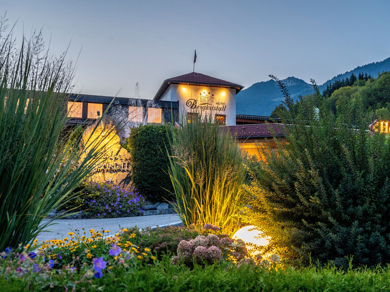 Hotel Bergkristall Sommer Außenansicht Dämmerung Gartenanlage