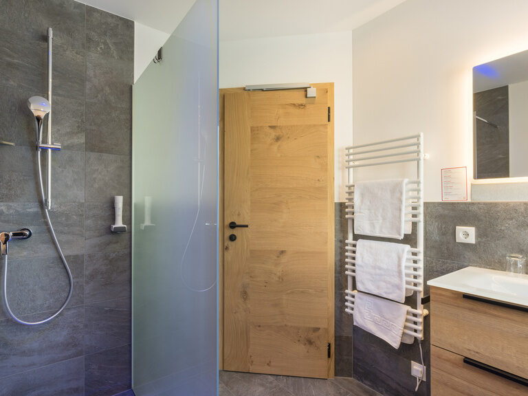 Doppelzimmer Wildried Badezimmer mit Alzholz modernes Badezimmer Hotel Bergkristall Silbertal